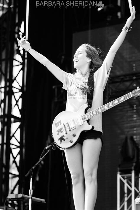 A Woman Standing On Top Of A Stage With Her Arms In The Air While