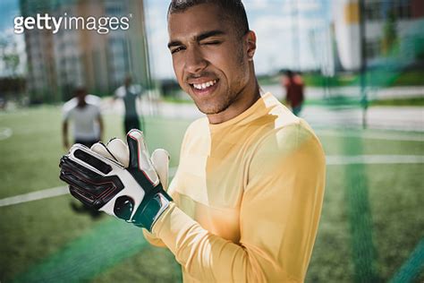 Portrait Of African American Goalkeeper In Soccer Gloves On Pitch