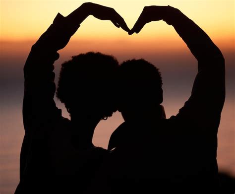 El corazón del atardecer y la silueta de una pareja en la playa