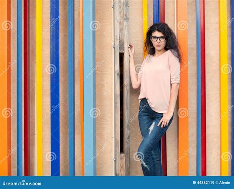 Schönes Großes Mädchen Mit Langem Haar Brunette in Den Gläsern Nahe Buntem Wandhintergrund