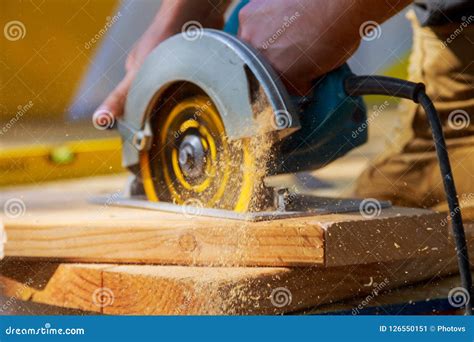 Carpenter Using Circular Saw For Cutting Wooden Boards With Hand Power