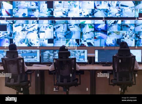 Security Guard Monitoring Modern CCTV Cameras In A Surveillance Room