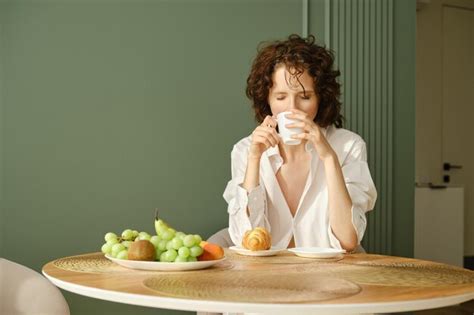 Premium Photo Sleepy Woman In White Shirt Worn Over Her Naked Body Takes First Sip Of