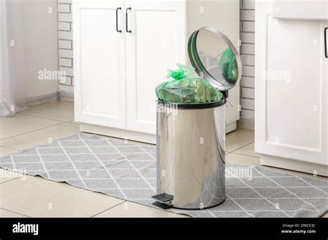 Full trash bin in interior of modern kitchen Stock Photo - Alamy