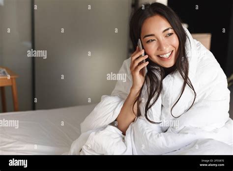 Portrait Of Silly And Cute Brunette Asian Girl Sitting On Her Bed