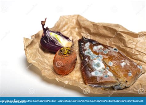 Moldy Fish with Rotten Carrot and Dried Onion on Crumpled Paper Stock ...