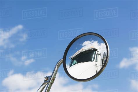 Reflection of semi-truck in side view mirror - Stock Photo - Dissolve