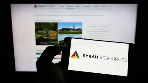 Person Holding Cellphone With Logo Of Australian Company Syrah