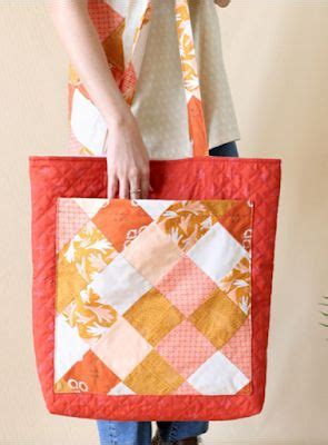 A Woman Is Holding A Quilted Tote Bag