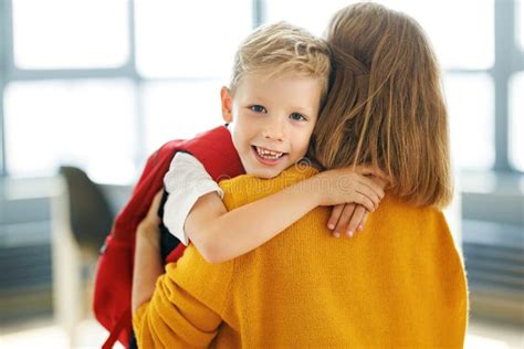 Niño Alegre Abraza a Mamá Antes Del Primer Día De Clases Foto de