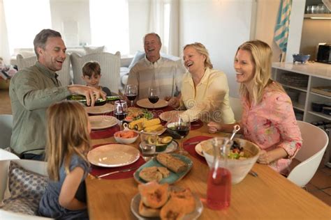 Família Que Reza Antes De Comer O Alimento Na Mesa De Jantar Imagem de