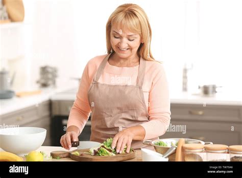 Beautiful Mature Woman Cooking In Kitchen Stock Photo Alamy