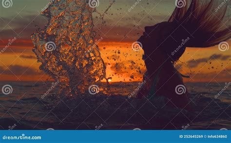 Silhouette Orange Sunset Shines On Playful Girl Splashing Water With