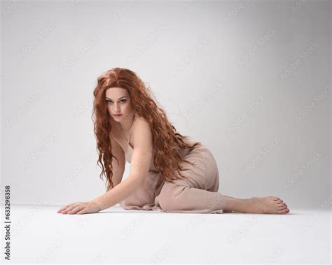 Full Length Portrait Of Beautiful Brunette Model Wearing A Pink Dress Graceful Sitting Pose