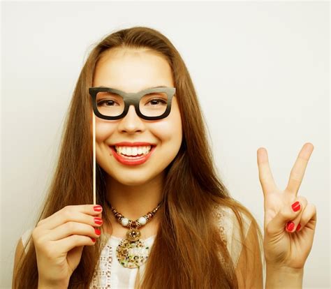 Imagen de fiesta mujeres jóvenes juguetonas sosteniendo unas gafas de