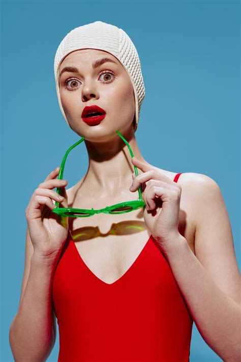 A Surprised Stunned Woman In A Swimming Cap And A Red Swimsuit Puts On