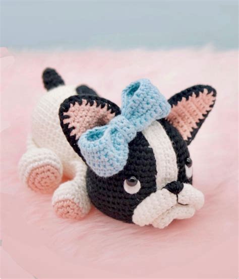 A Black And White Cat With A Blue Bow On It S Head Laying Down