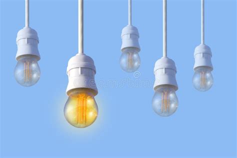 A Row Of White Electric Light Bulbs On A Blue Background Stock Photo