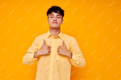 Premium Photo Cheerful Young Man In A Yellow Shirt Gestures With His