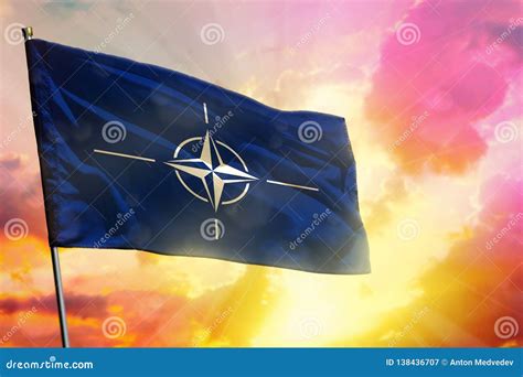 Fluttering Nato Flag On Beautiful Colorful Sunset Or Sunrise Background