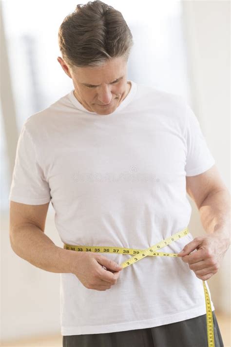 Homem Que Mede Sua Cintura No Health Club Foto De Stock Imagem De