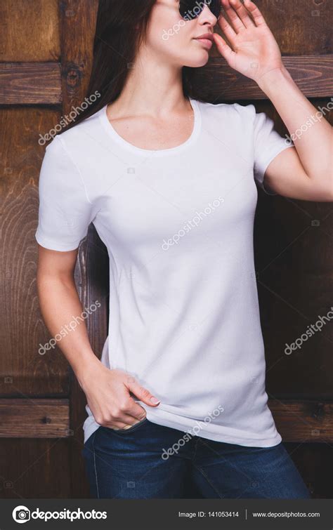 Woman Wearing White T Shirt In Front Of Wooden Wall Stock Photo By