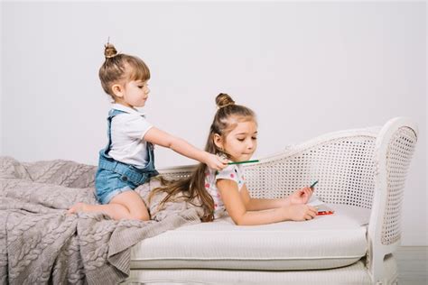 Free Photo Two Girls On Sofa With Pencils And Paper