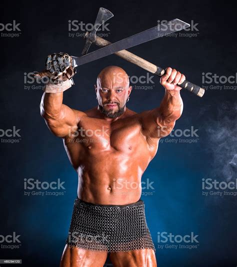 Handsome Muscular Ancient Warrior With Axe And Sword Stock Photo