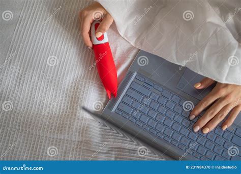 A Woman Lies In Bed Holding A Clitoral Vibrator And Watching On A Laptop The Girl Has Sex