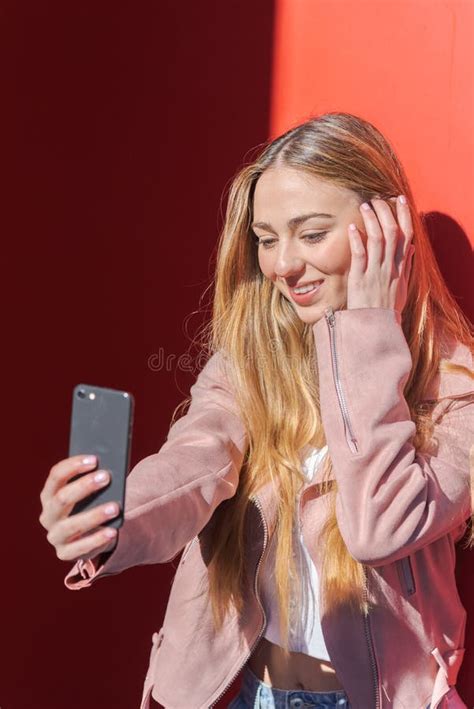 Jovem Fotografando Se Um Celular De Fundo Vermelho Foto De Stock