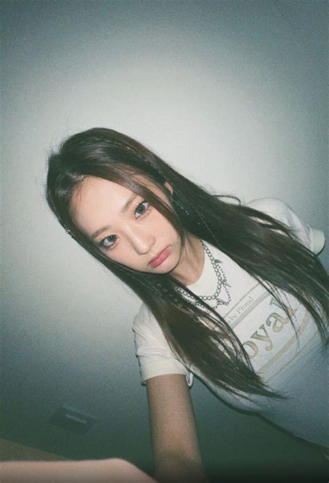 A Woman With Long Hair Standing In Front Of A Wall