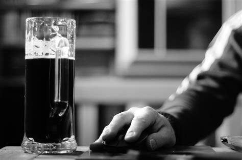 Premium Photo Close Up Of Hand Holding Beer Glass On Table