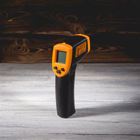 Yellow Black Pyrometer On A Wooden Background A Device For Non Contact