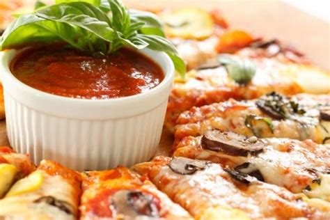 The Pizza Is Covered In Sauce And Garnished With Basil