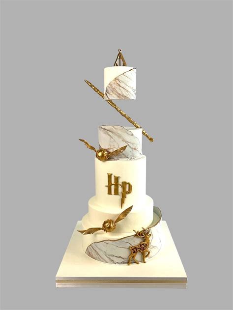 A Three Tiered Cake With Harry Potter Decorations