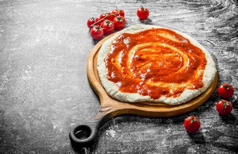 Premium Photo | Preparation pizza dough on a cutting board with cherry tomatoes