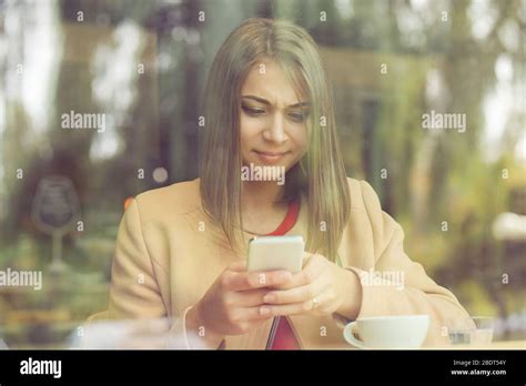 Upset Stressed Woman Holding Cellphone Disgusted With Message She