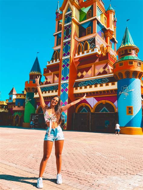 A Woman Standing In Front Of A Colorful Castle