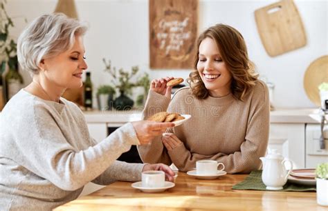 Cheerful Mother And Daughter Drinking Coffee At Home Stock Image