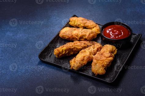 Fried Crispy Chicken Nuggets With Ketchup On Black Plate On A Dark