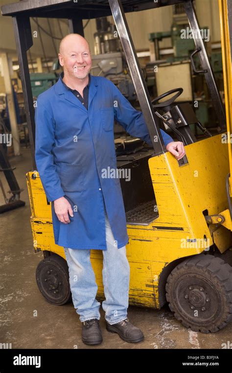 Warehouse Worker Standing By Forklift Stock Photo Alamy