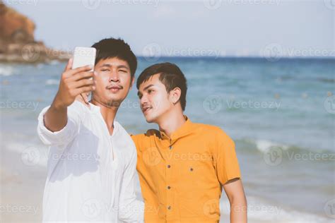 portrait gay jeune couple souriant prenant une photo de selfie avec un téléphone portable