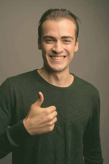 Premium Photo Portrait Of Smiling Man Standing Against Gray Background