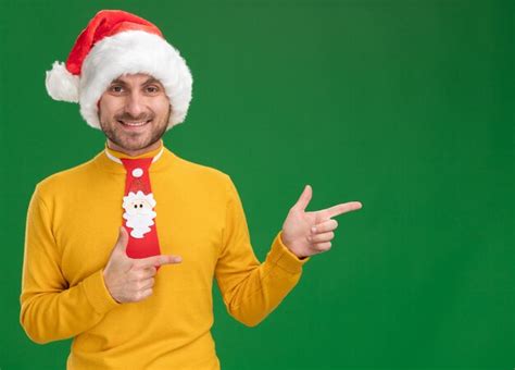 Free Photo Joyful Young Caucasian Man Wearing Christmas Hat And Tie