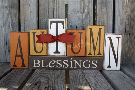 A Wooden Block Sign That Says Autumn And The Word Blessing Is Made Out