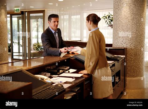 Man Checking In At The Hotel Reception Desk Stock Photo Alamy