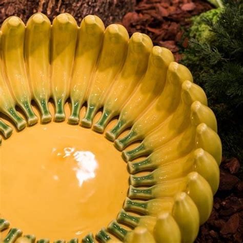 A Yellow Bowl Sitting On The Ground Next To A Tree