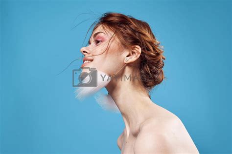 Pretty Woman Naked Shoulders And Fluffy Earrings Bright Makeup Blue Background By SHOTPRIME