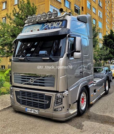 a silver truck parked in front of a tall building