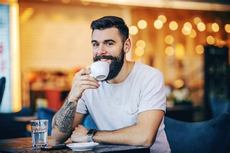 Premium Photo Young Muscular Caucasian Hipster Drinking Coffee In